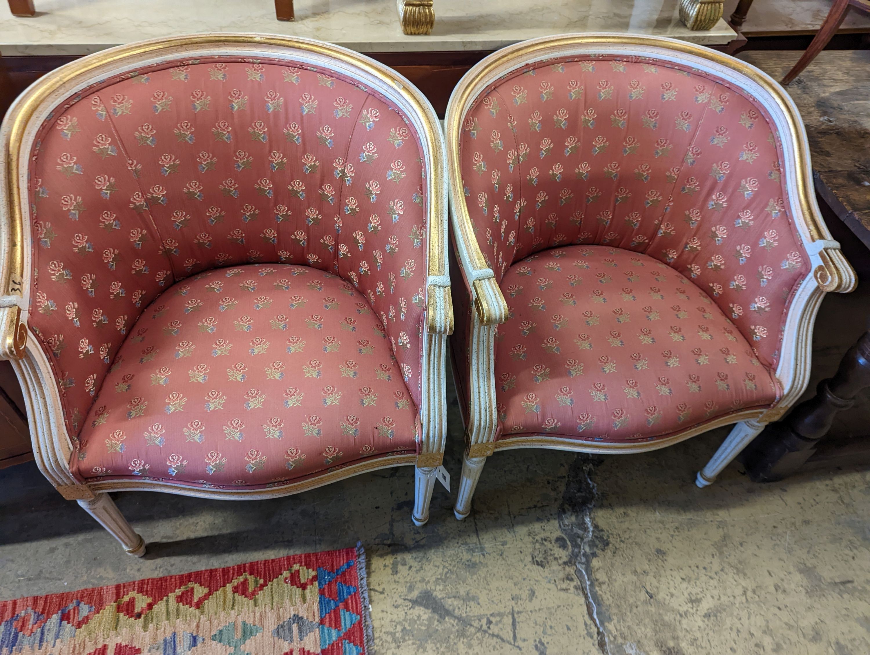 A pair of Louis XVI design painted parcel gilt tub framed chairs, width 65cm, depth 45cm, height 81cm